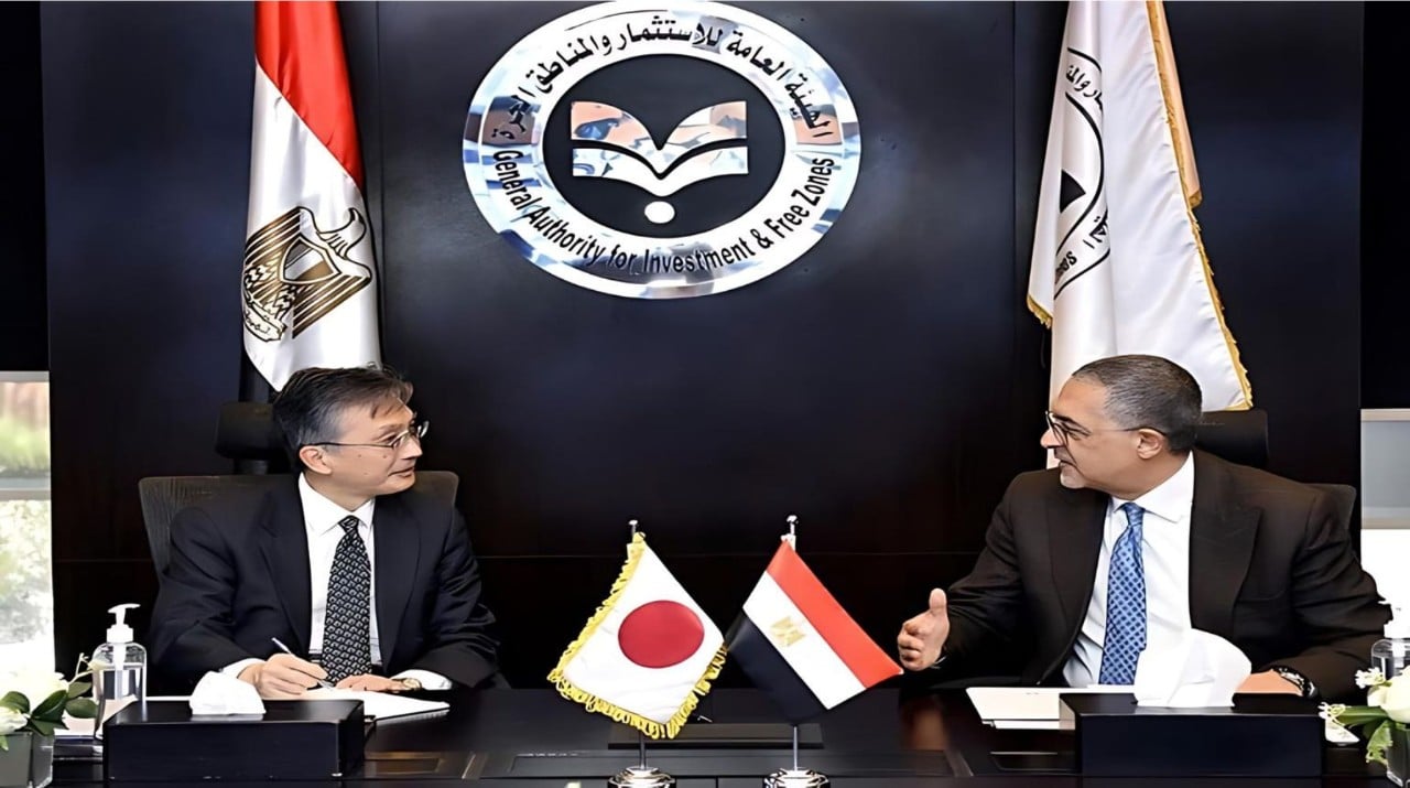 Representative of Japanese firm, and Representative of Egyptian investment authority seated at a conference table in mid-discussion, with the flags of Japan and Egypt prominently displayed between them. Behind them, a logo reading "General Authority for Investment & Free Zones".